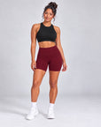 Sculpt Bike Shorts in burgundy styled with black crop top, full length front view