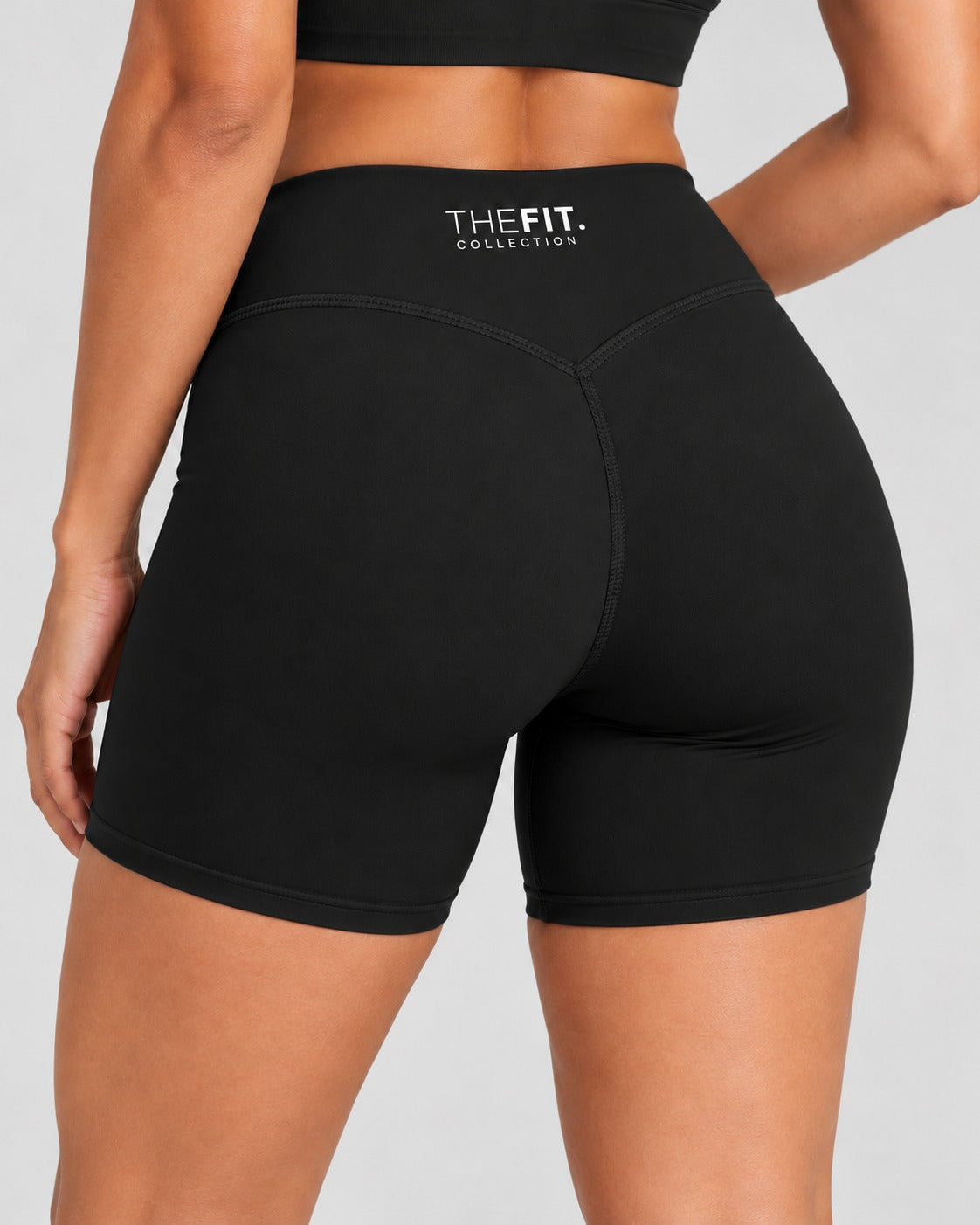 Black sculpt bike shorts, back close-up showing V-seam and THE FIT. COLLECTION logo