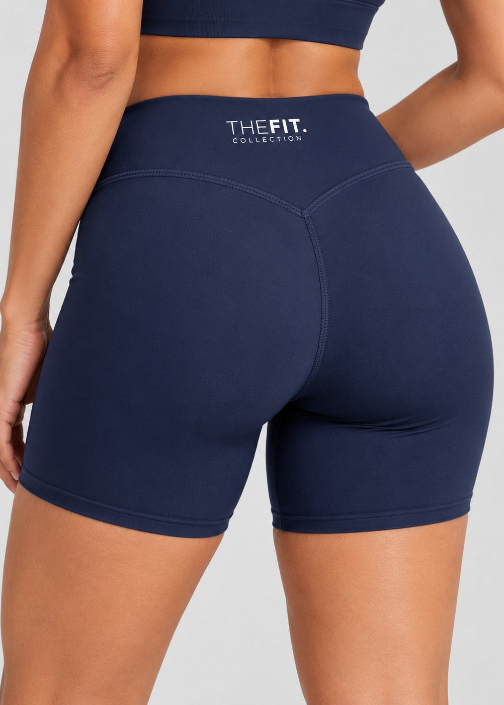 Navy sculpt bike shorts, back close-up showing V-seam and THE FIT. COLLECTION logo