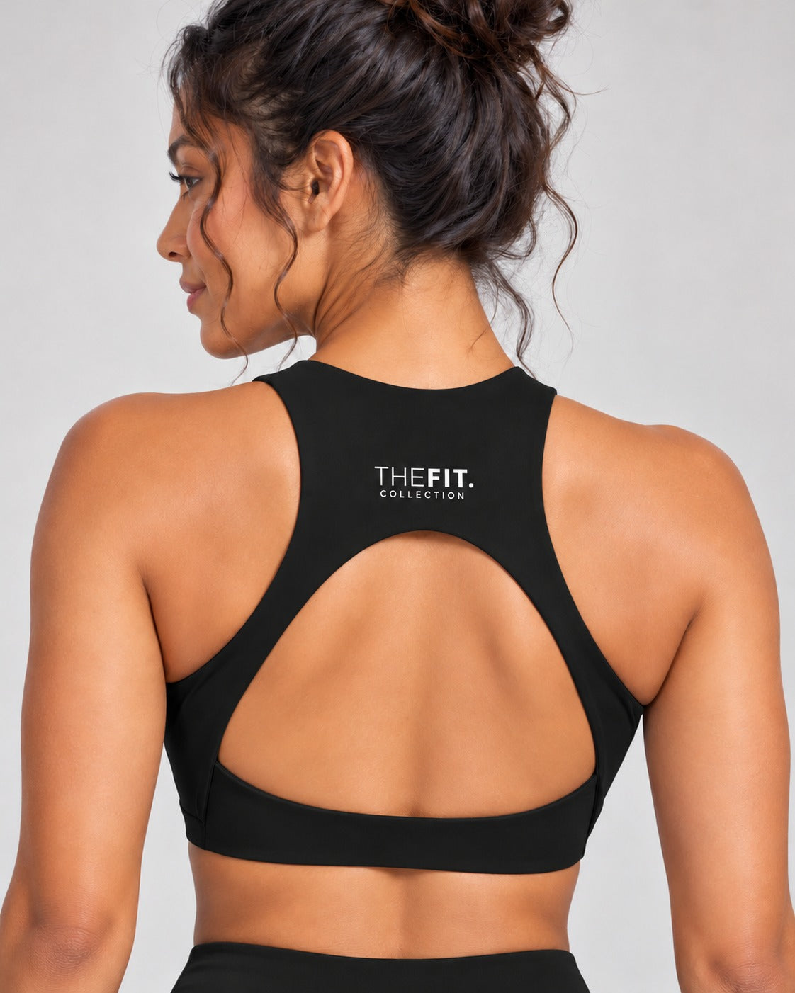 Black crop top back view showing racer back, teardrop cut-out and THE FIT. COLLECTION logo