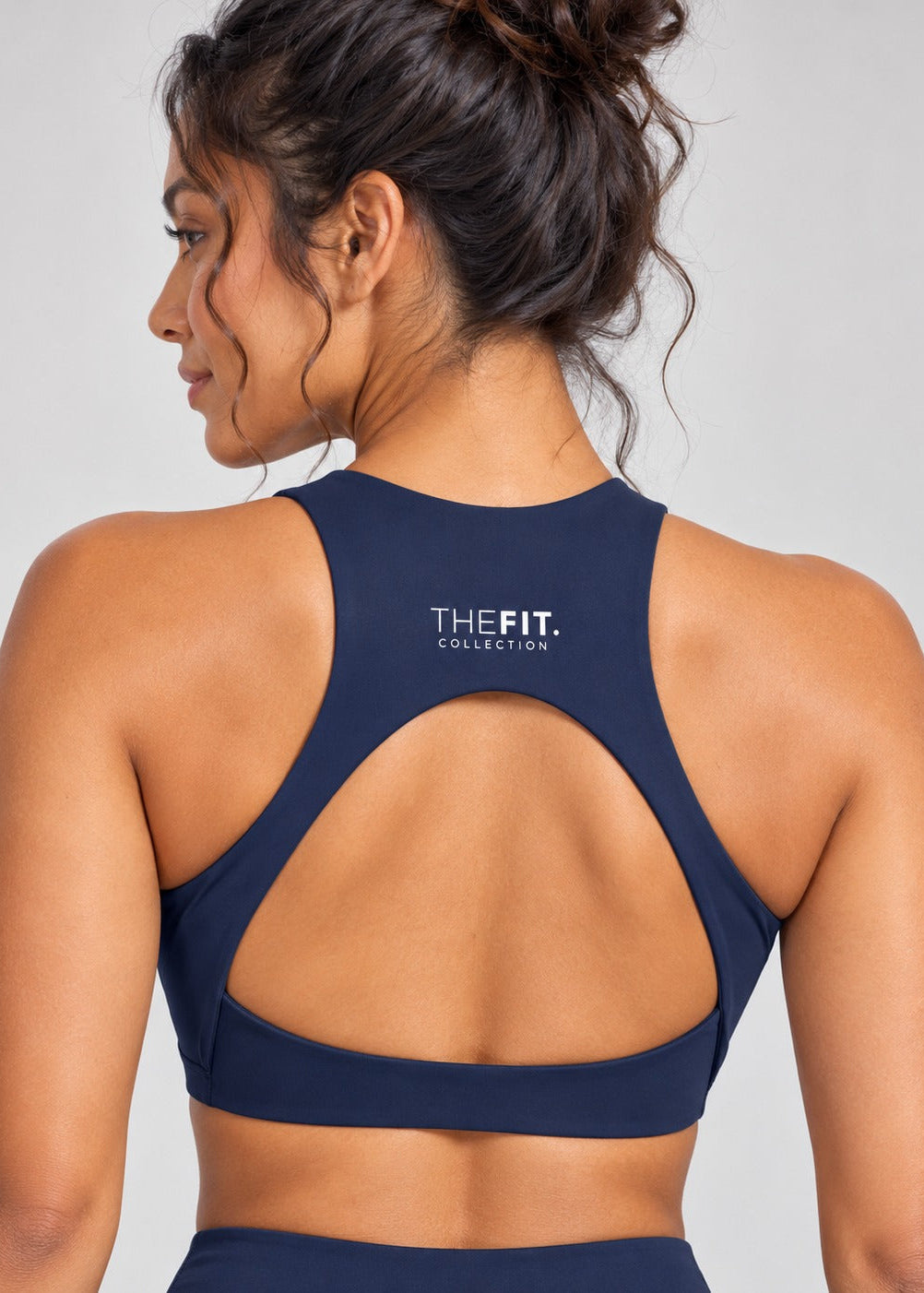Navy crop top back view showing racer back, teardrop cut-out and THE FIT. COLLECTION logo